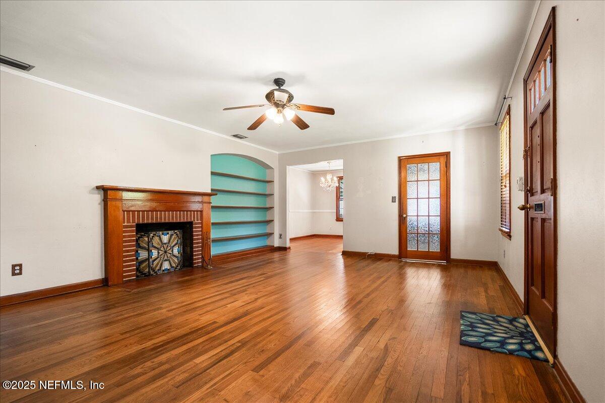 5249 Birkenhead Road Jacksonville, FL 32210 - Photo 3 of 32 a view of an empty room with wooden floor fireplace and a window