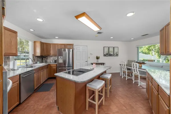 a kitchen with stainless steel appliances kitchen island granite countertop a sink and cabinets