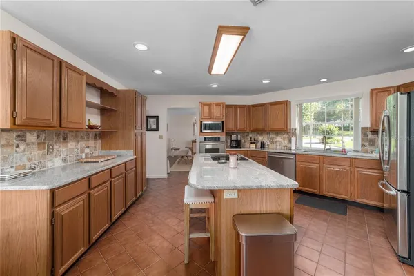 a kitchen with stainless steel appliances kitchen island granite countertop a sink and cabinets