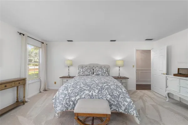 a bedroom with a large bed and a window
