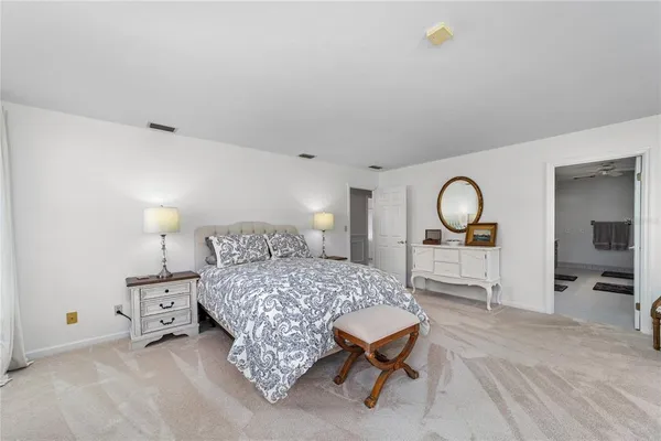 a bedroom with a bed mirror and a table