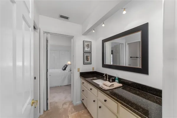 a bathroom with a granite countertop sink and a mirror