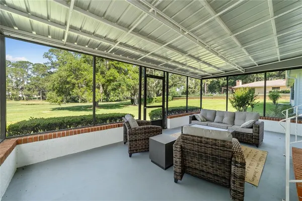 a living room with furniture and a floor to ceiling window plants and tree