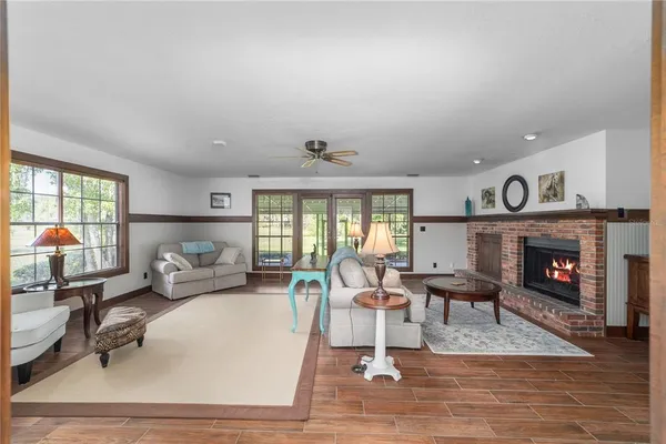 a living room with furniture large window and a fireplace
