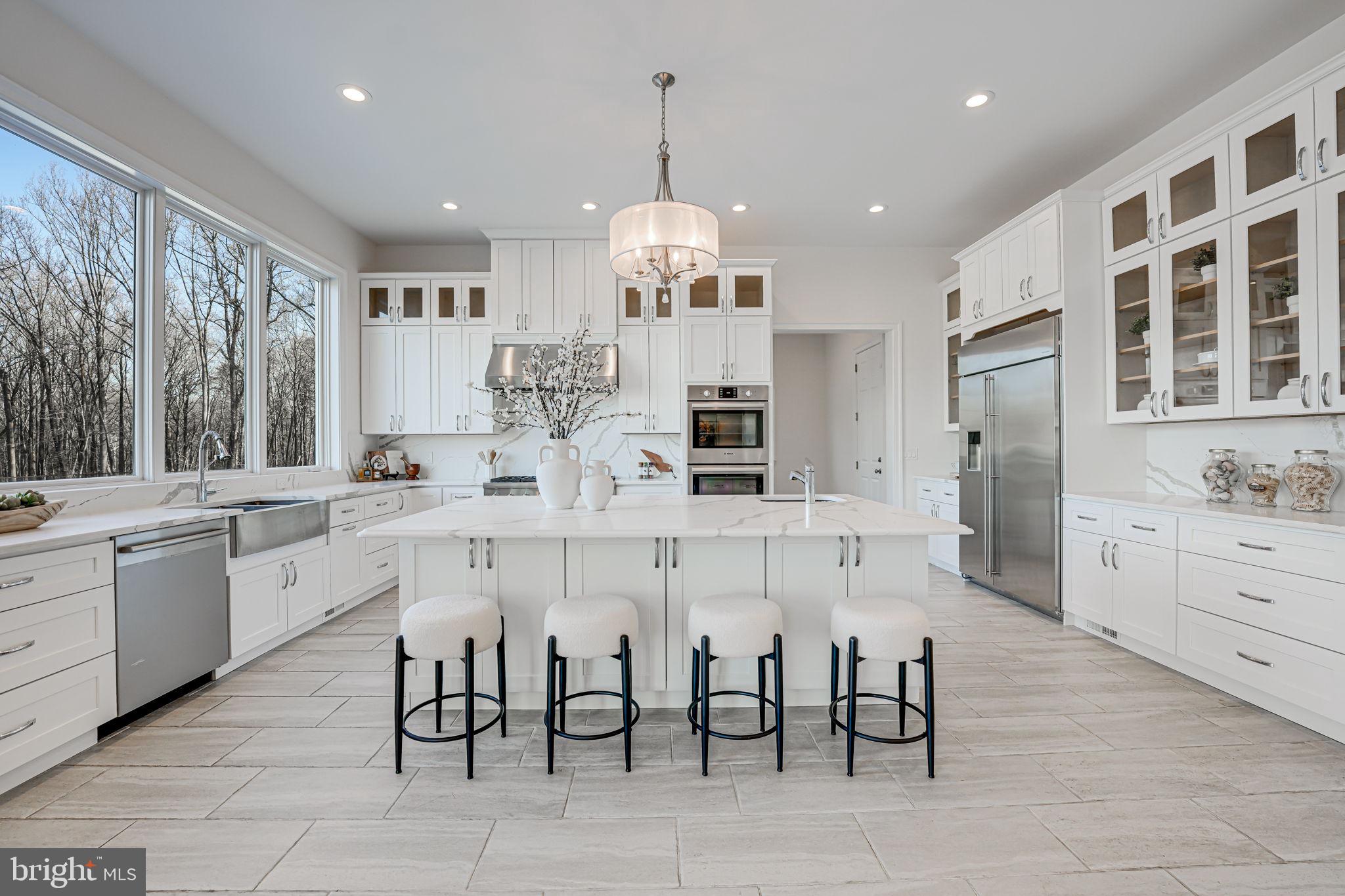10305 Beach Mill Road Great Falls, VA 22066 - Photo 26 of 74 a large kitchen with kitchen island granite countertop lots of white cabinets appliances dining table and chairs