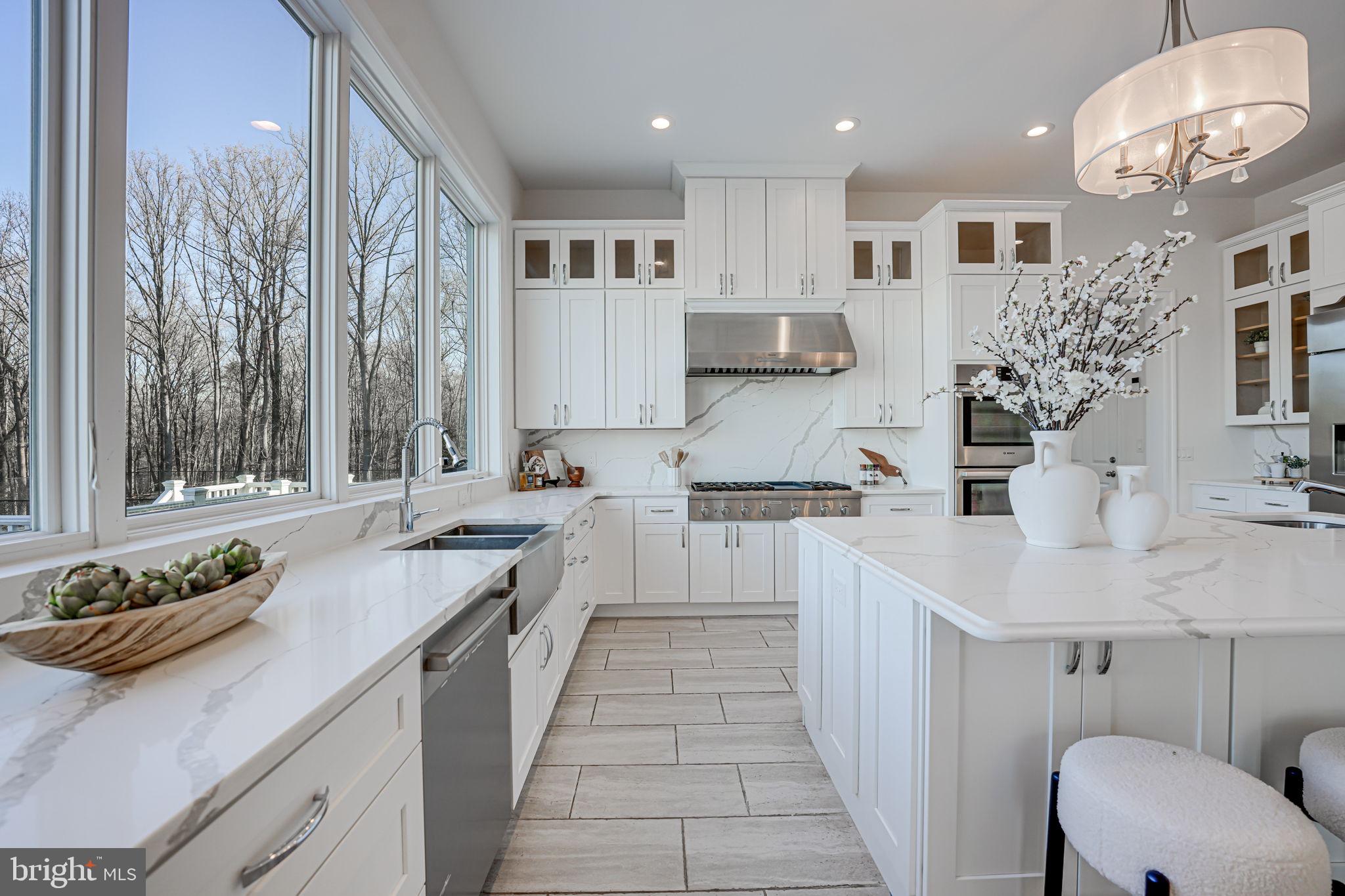 10305 Beach Mill Road Great Falls, VA 22066 - Photo 27 of 74 a large white kitchen with stainless steel appliances lots of counter space and a sink