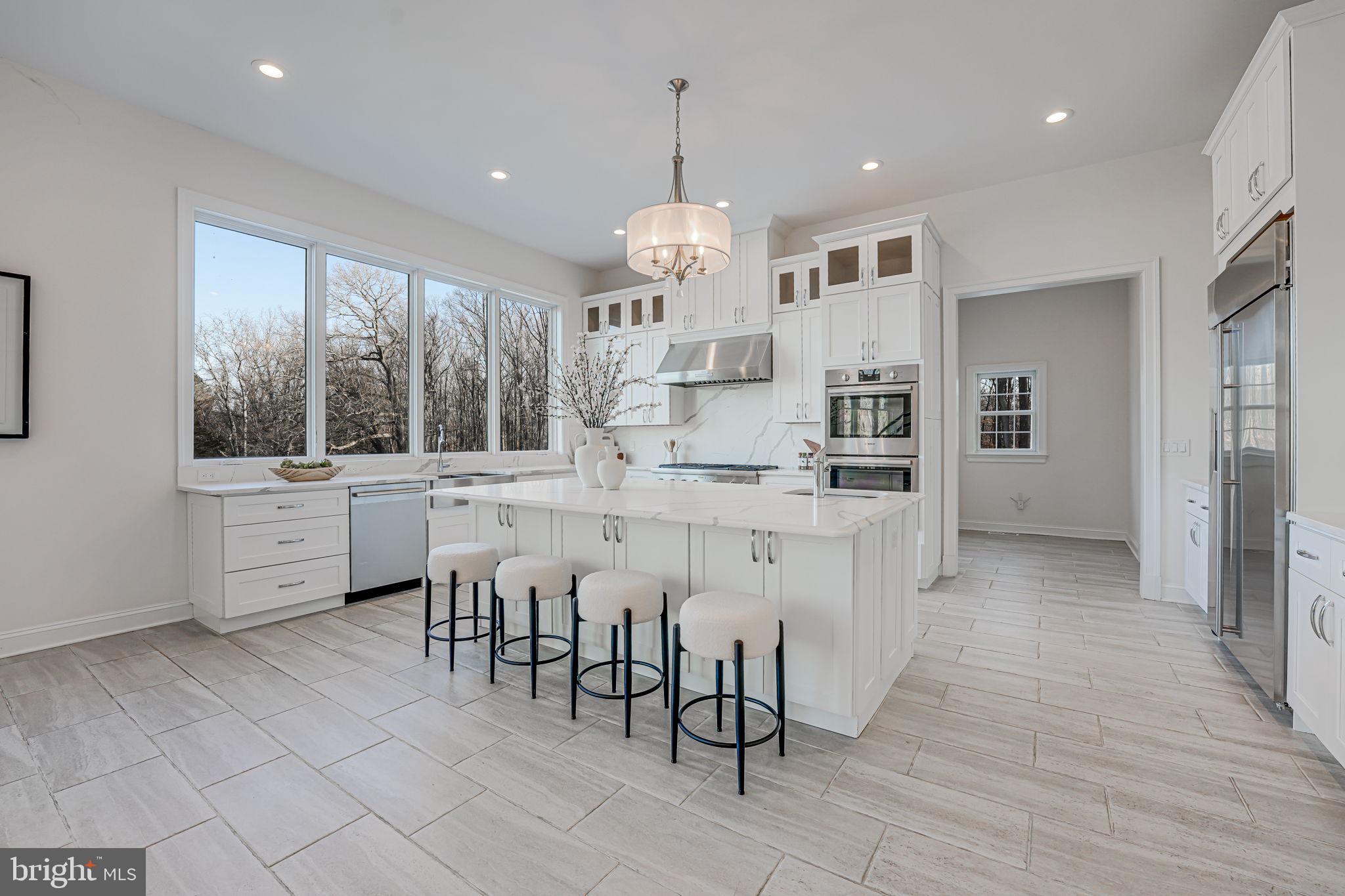 10305 Beach Mill Road Great Falls, VA 22066 - Photo 30 of 74 a open kitchen with white cabinets and stainless steel appliances