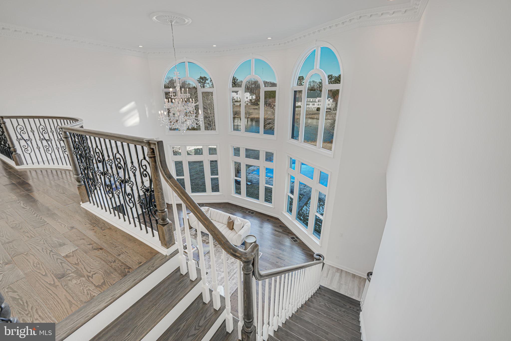 10305 Beach Mill Road Great Falls, VA 22066 - Photo 35 of 74 a view of staircase with lots of frames on wall and windows