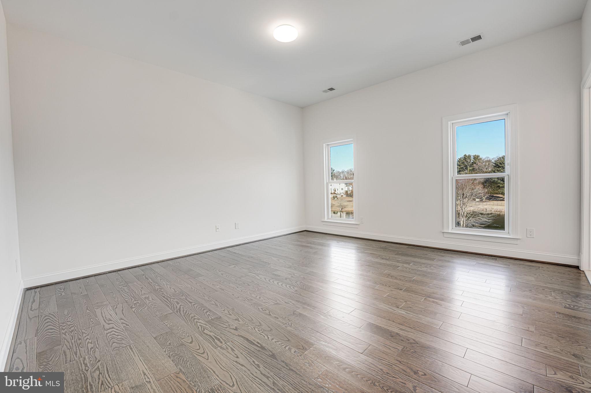 10305 Beach Mill Road Great Falls, VA 22066 - Photo 55 of 74 an empty room with wooden floor and windows