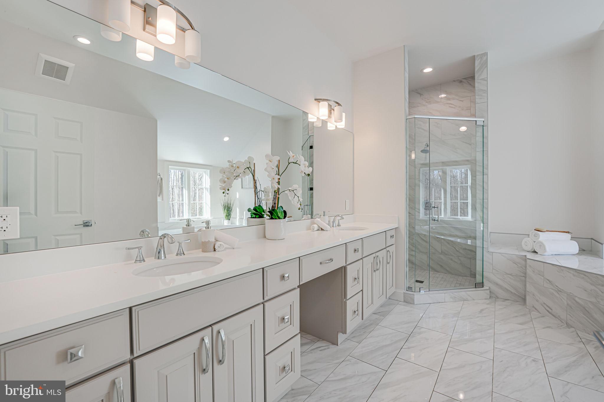 10305 Beach Mill Road Great Falls, VA 22066 - Photo 58 of 74 a spacious bathroom with a granite countertop sink a toilet a mirror and vanity