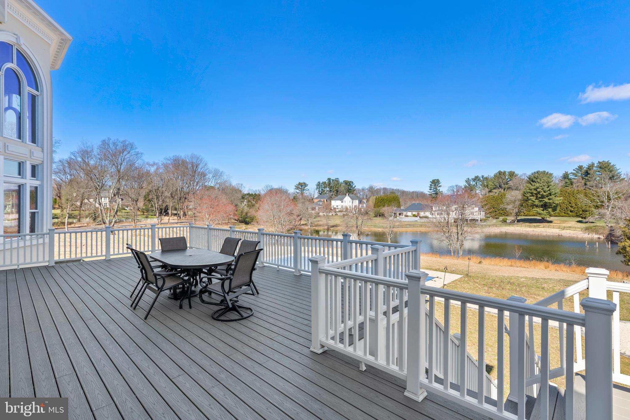 10305 Beach Mill Road Great Falls, VA 22066 - Photo 64 of 74 a view of a balcony with table and chairs and wooden floor