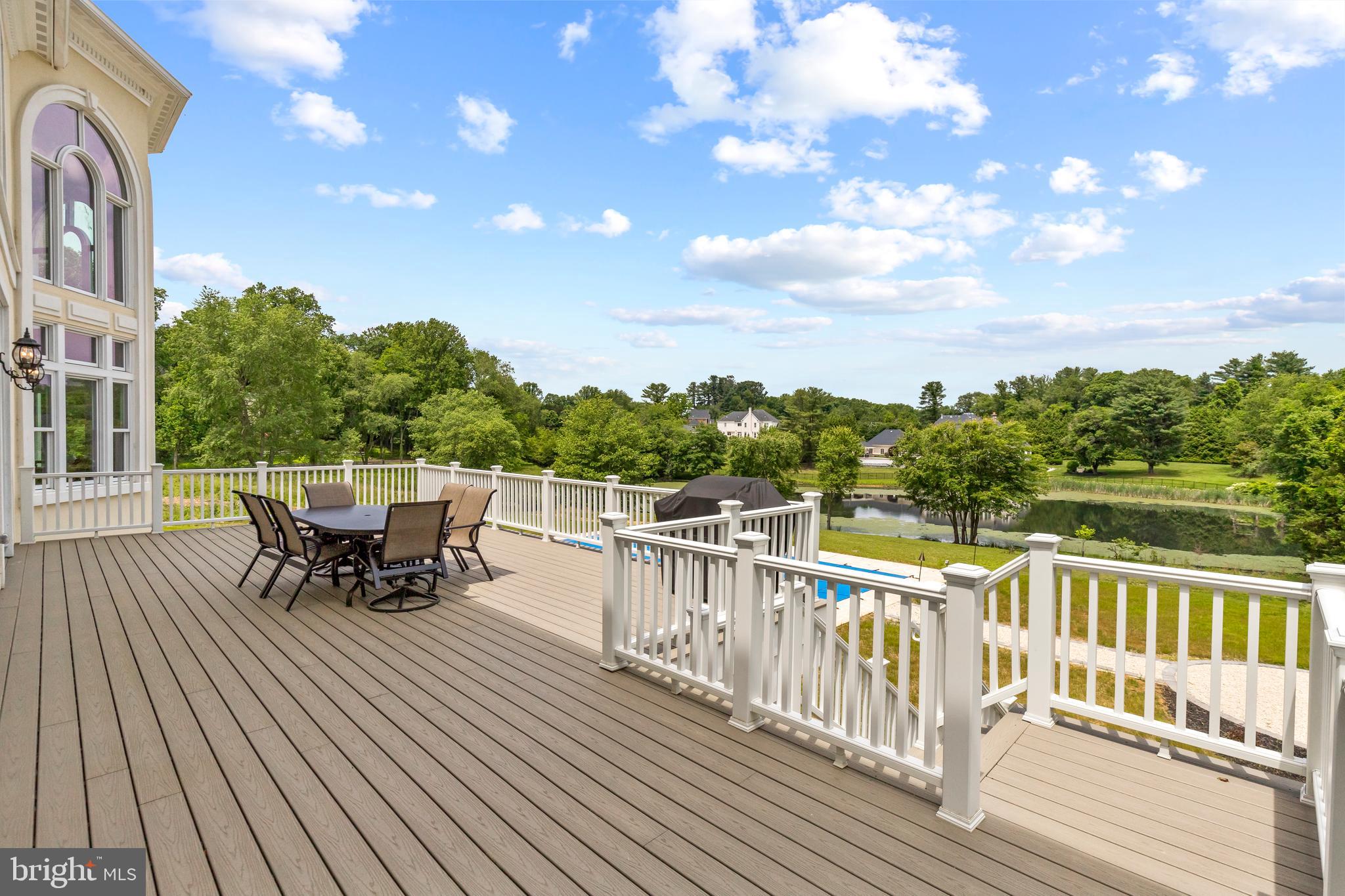 10305 Beach Mill Road Great Falls, VA 22066 - Photo 67 of 74 a view of a roof deck with table and chairs a barbeque with wooden floor and fence