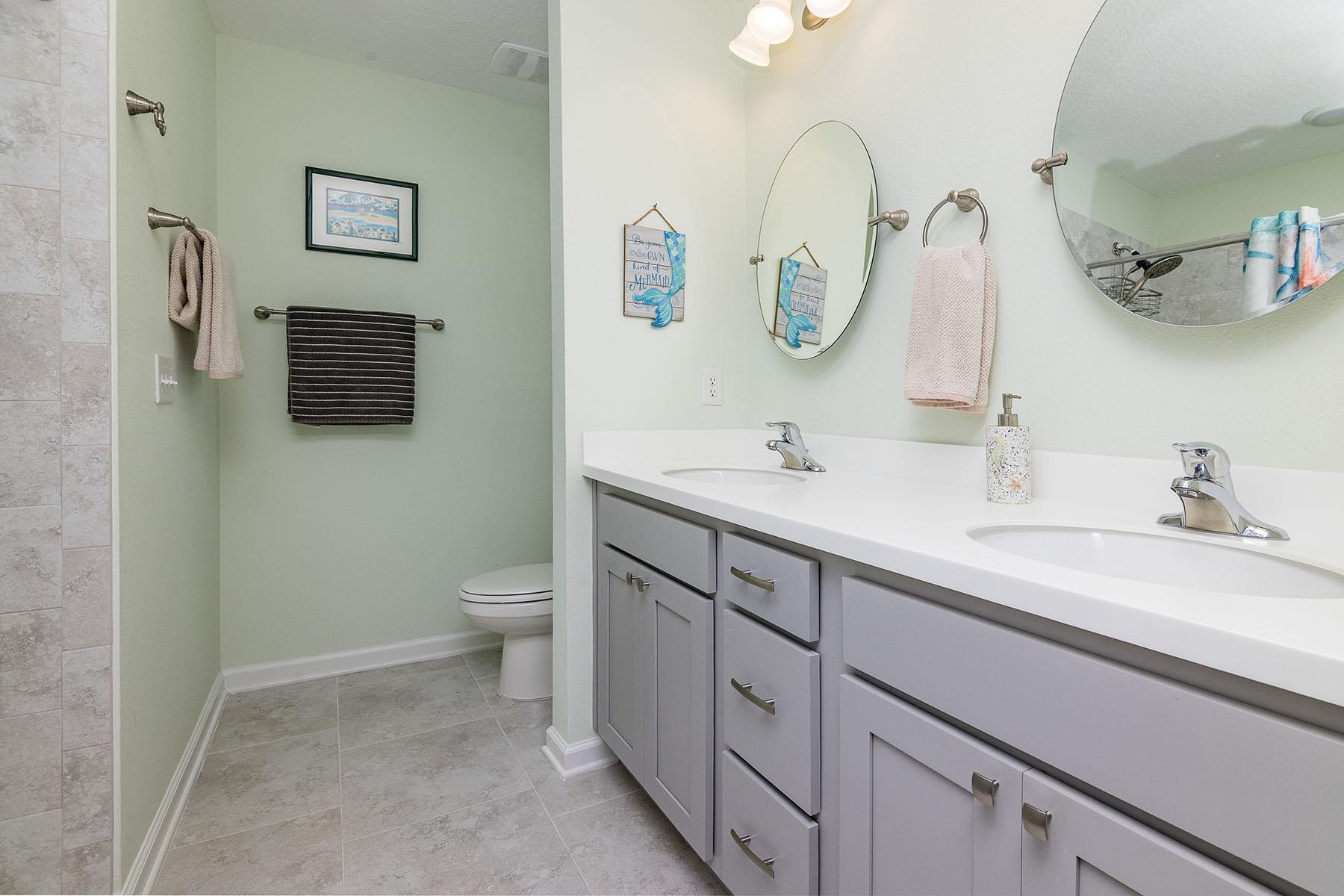 74 Ridge Lake Road St. Augustine, FL 32086 - Photo 28 of 47 Full bath with double vanity, light tile patterned floors, and tiled shower