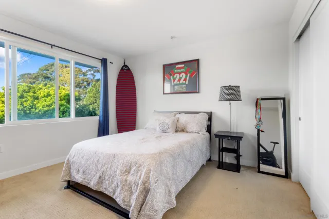 a bedroom with a bed and a large window