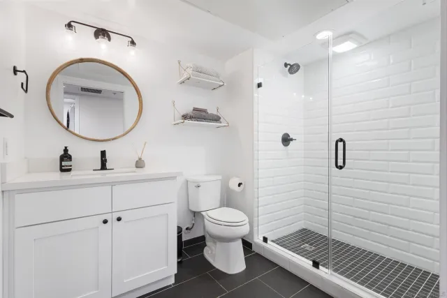 a bathroom with a toilet a sink a mirror and vanity