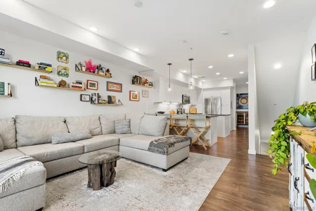 a living room with furniture and a dining table with kitchen view