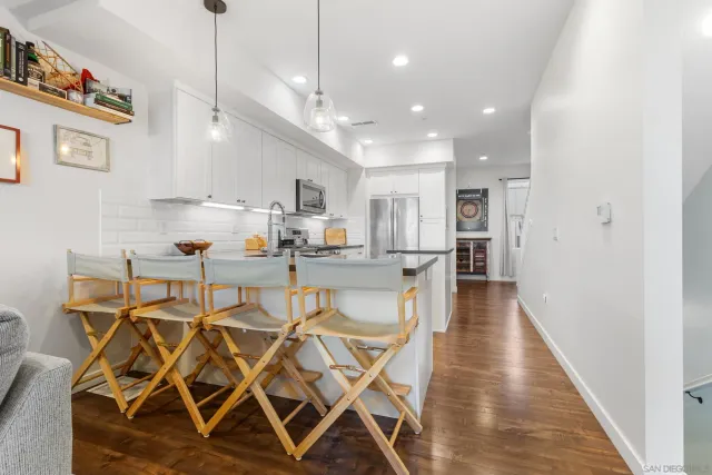 a view of a dining room and livingroom with furniture wooden floor a chandelier