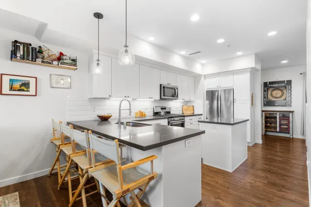 a kitchen with a table chairs refrigerator and microwave