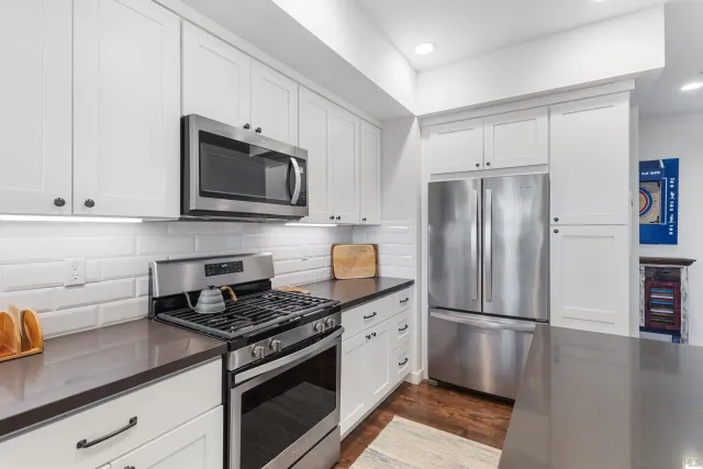 a kitchen with granite countertop a refrigerator stove and microwave