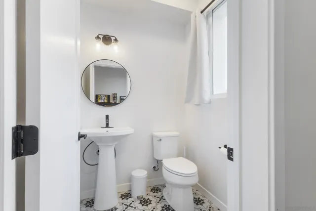 a bathroom with a toilet sink and mirror