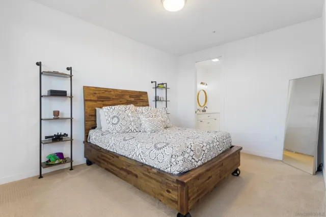 a bedroom with a bed a mirror and dresser