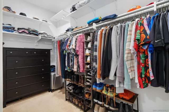 a view of walk in closet with clothes and shoes