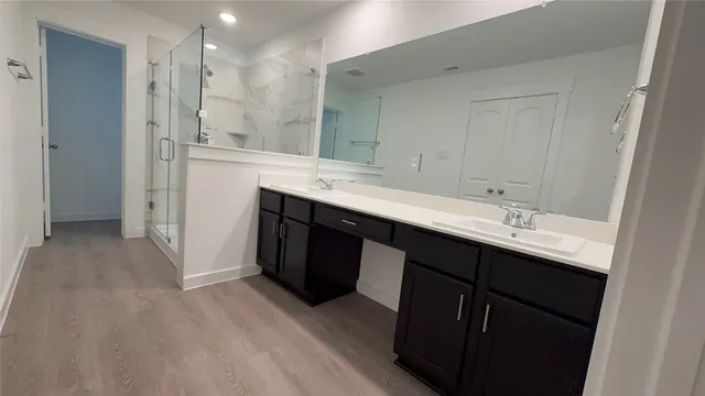 a bathroom with a double vanity sink mirror and shower