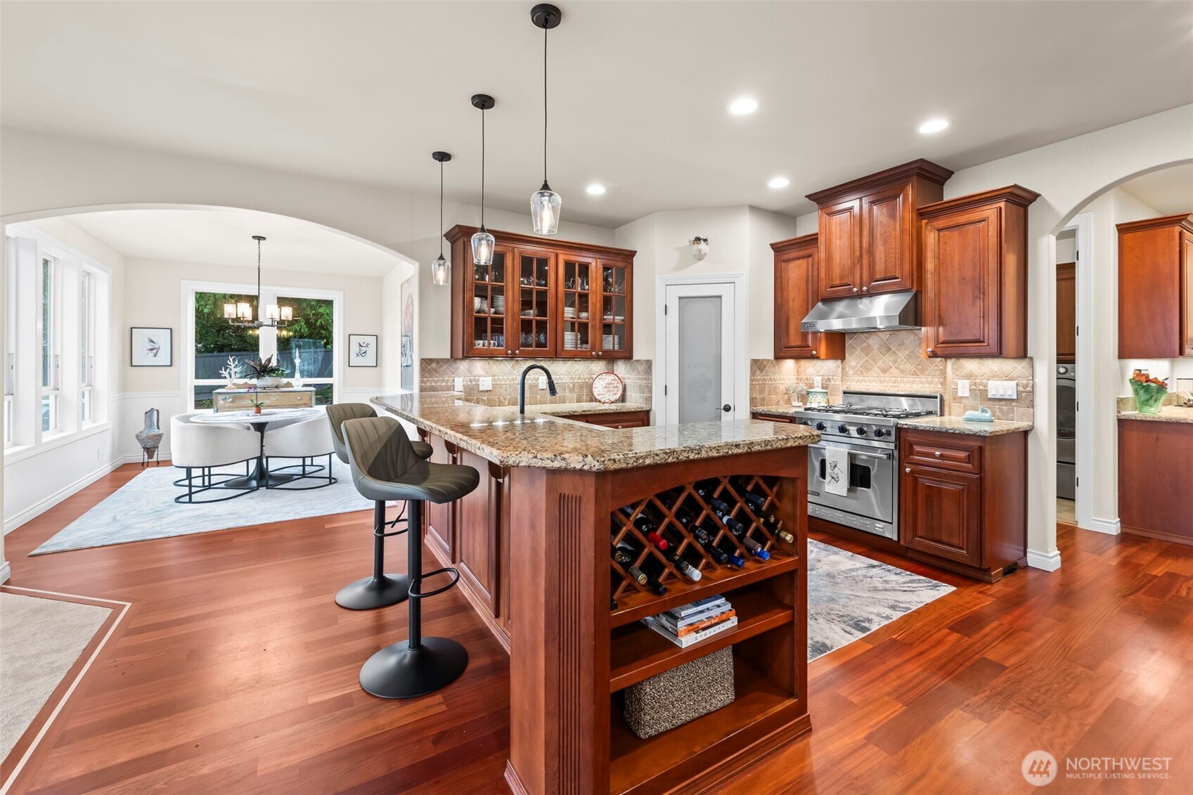 2702 60th Street Northwest Gig Harbor, WA 98335 - Photo 12 of 40 a kitchen with stainless steel appliances granite countertop a stove refrigerator and a dining table with wooden floor