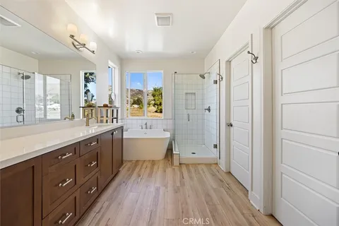 a spacious bathroom with a double vanity sink a large mirror and shower