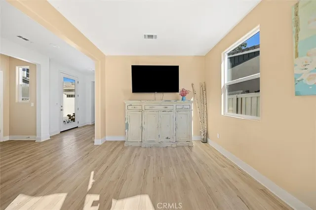 a view of a livingroom with wooden floor and a flat screen tv