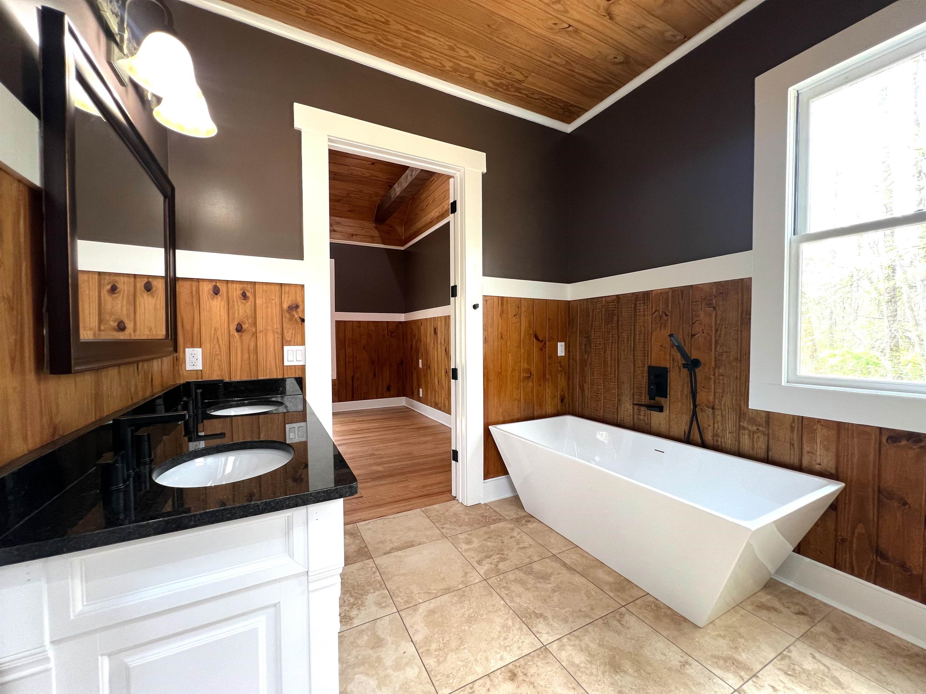 9490 Highway 196 Collierville, TN 38017 - Photo 20 of 40 Full bath with wooden walls, double vanity, a freestanding bath, wood ceiling, and wainscoting