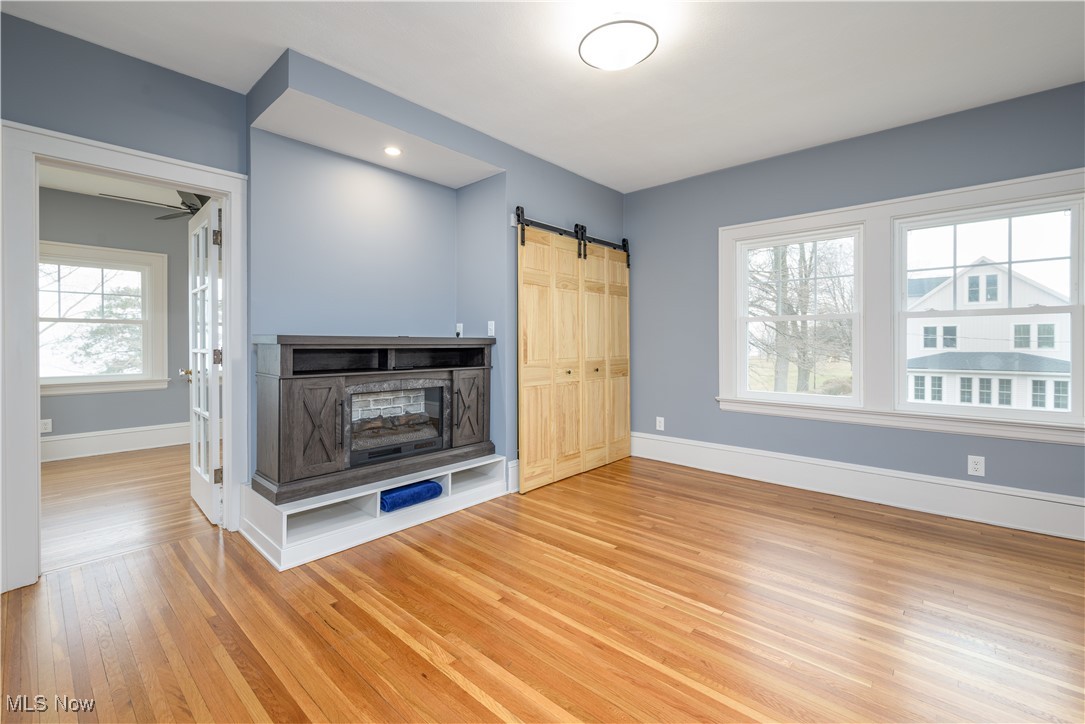 17728 Windward Road Cleveland, OH 44119 - Photo 19 of 32 Unfurnished living room with wood-type flooring and a barn door