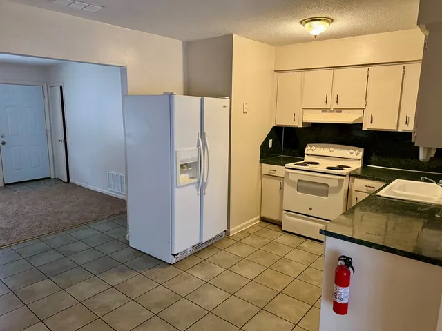 a kitchen with a refrigerator and a stove