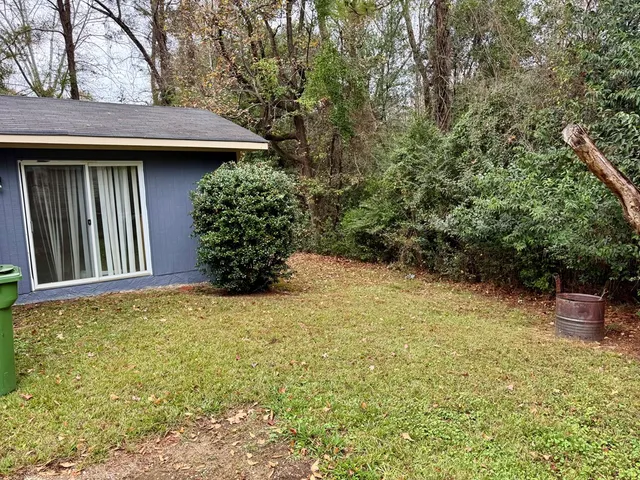 a view of a house with a yard and potted plants
