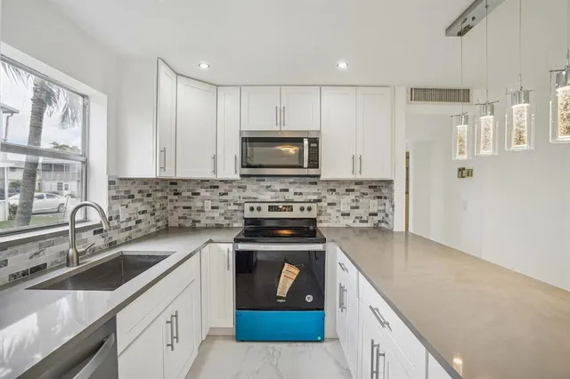 a kitchen with a sink stove and cabinets