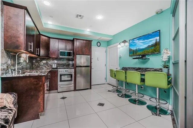 a kitchen with stainless steel appliances granite countertop a stove a sink and a microwave