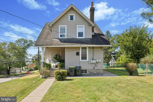 a front view of a house with a yard and trees
