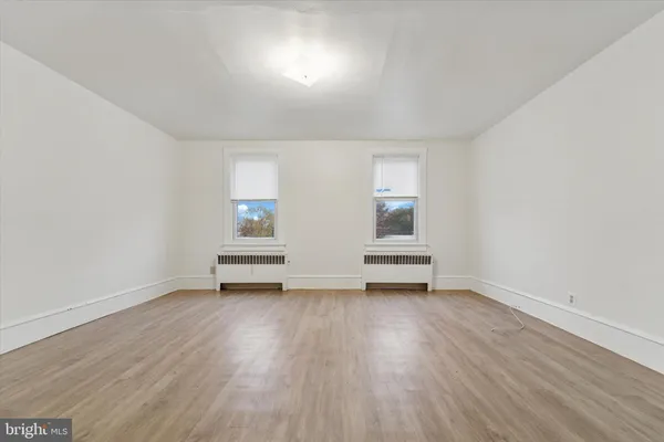 an empty room with wooden floor and window