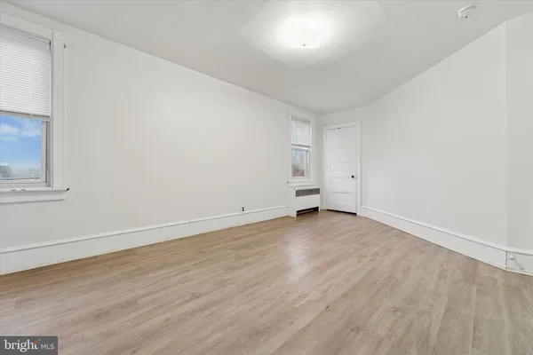 an empty room with wooden floor and empty shelves