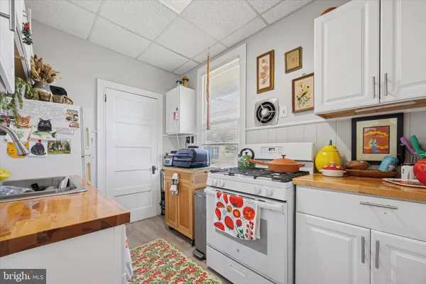 a utility room with stainless steel appliances granite countertop a stove and a sink