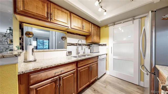a kitchen with stainless steel appliances granite countertop a refrigerator and a sink