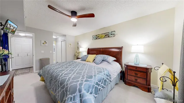 a bedroom with a bed and a ceiling fan