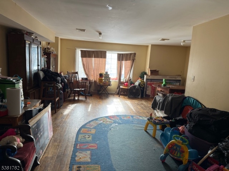 12 Amity Street, Unit 2 Paterson, NJ 07522 - Photo 14 of 14 a living room with furniture chess board and a flat screen tv