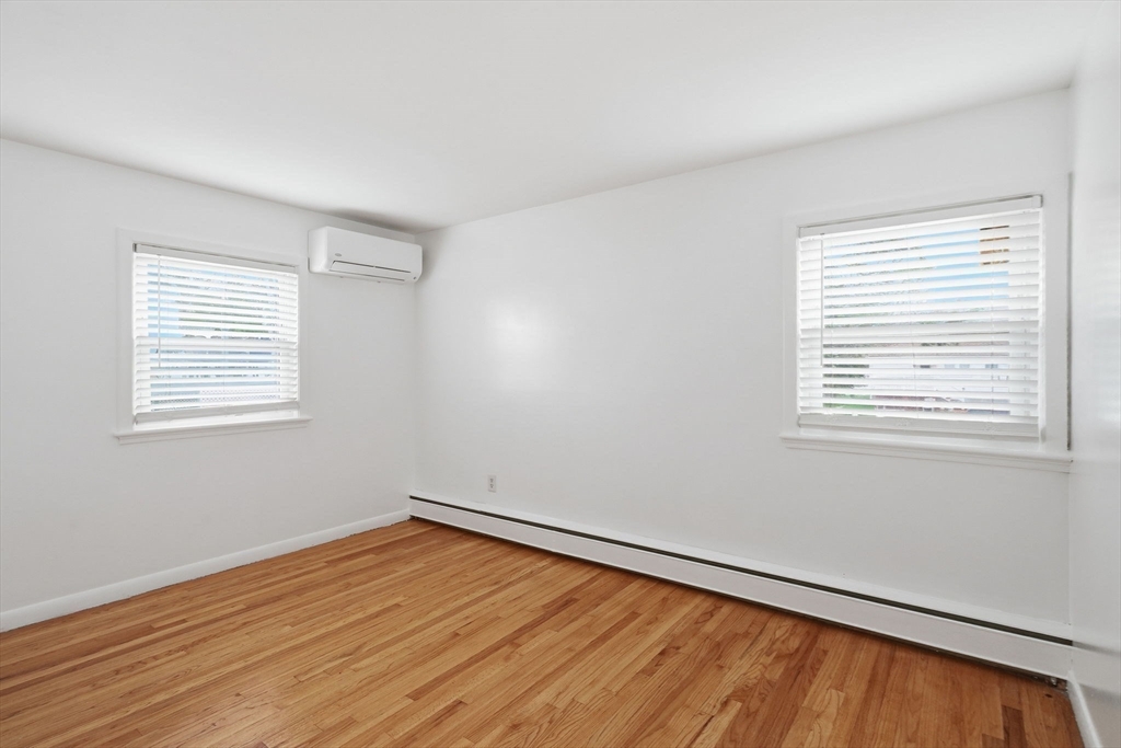 126 Summer Street Boston, MA 02136 - Photo 15 of 28 a view of an empty room with wooden floor and a window