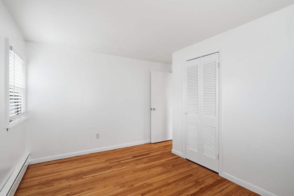 126 Summer Street Boston, MA 02136 - Photo 16 of 28 a view of an empty room with wooden floor