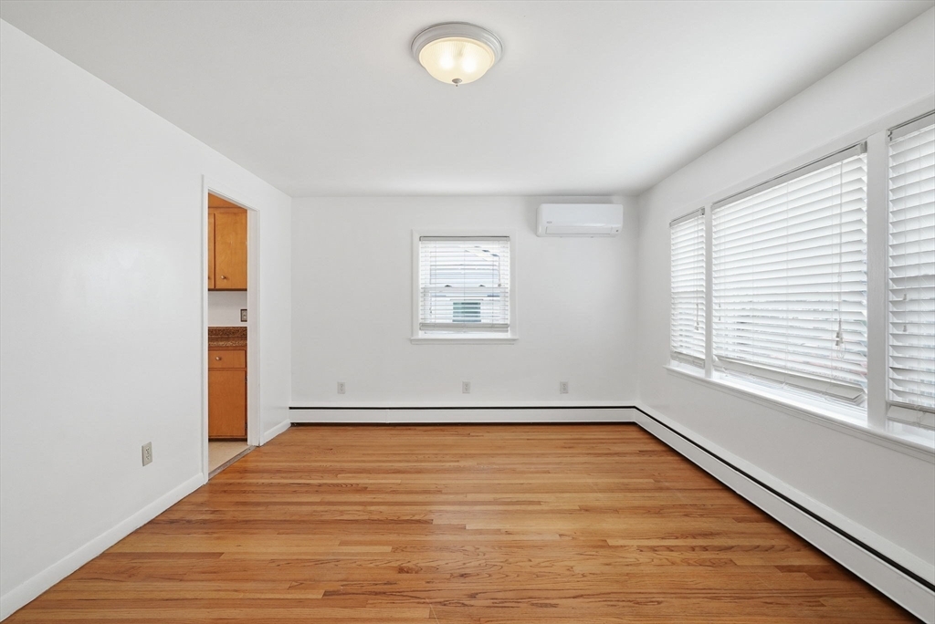 126 Summer Street Boston, MA 02136 - Photo 5 of 28 an empty room with wooden floor and windows