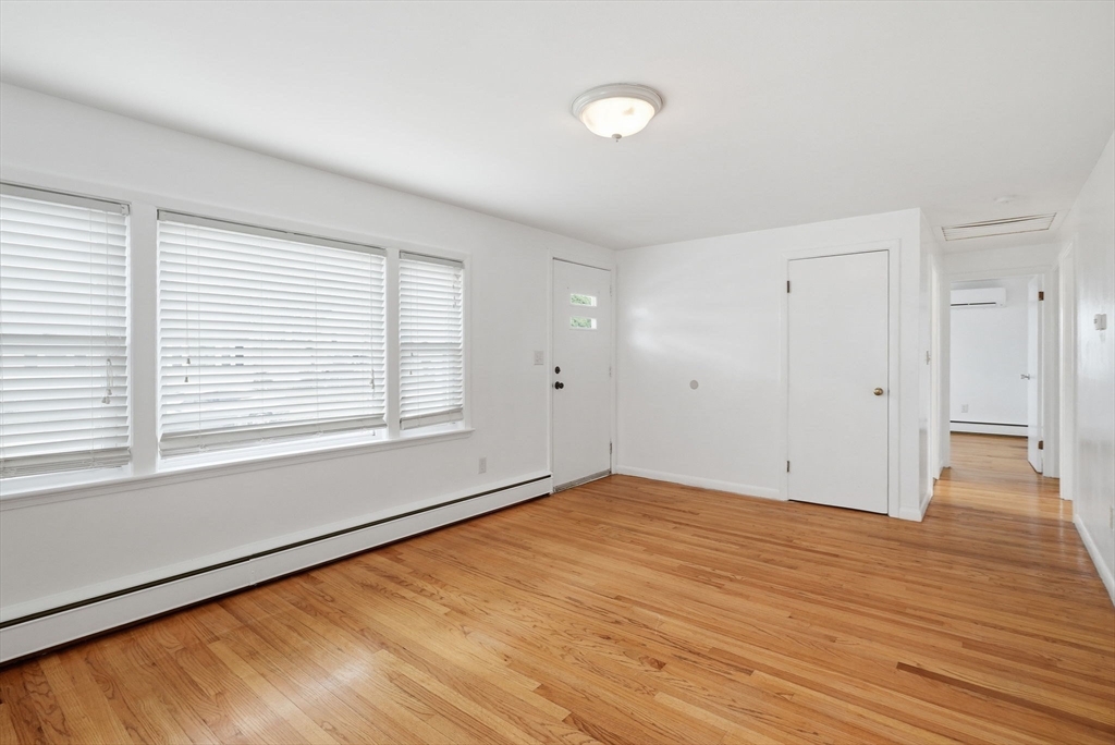 126 Summer Street Boston, MA 02136 - Photo 6 of 28 a view of an empty room with wooden floor and a window