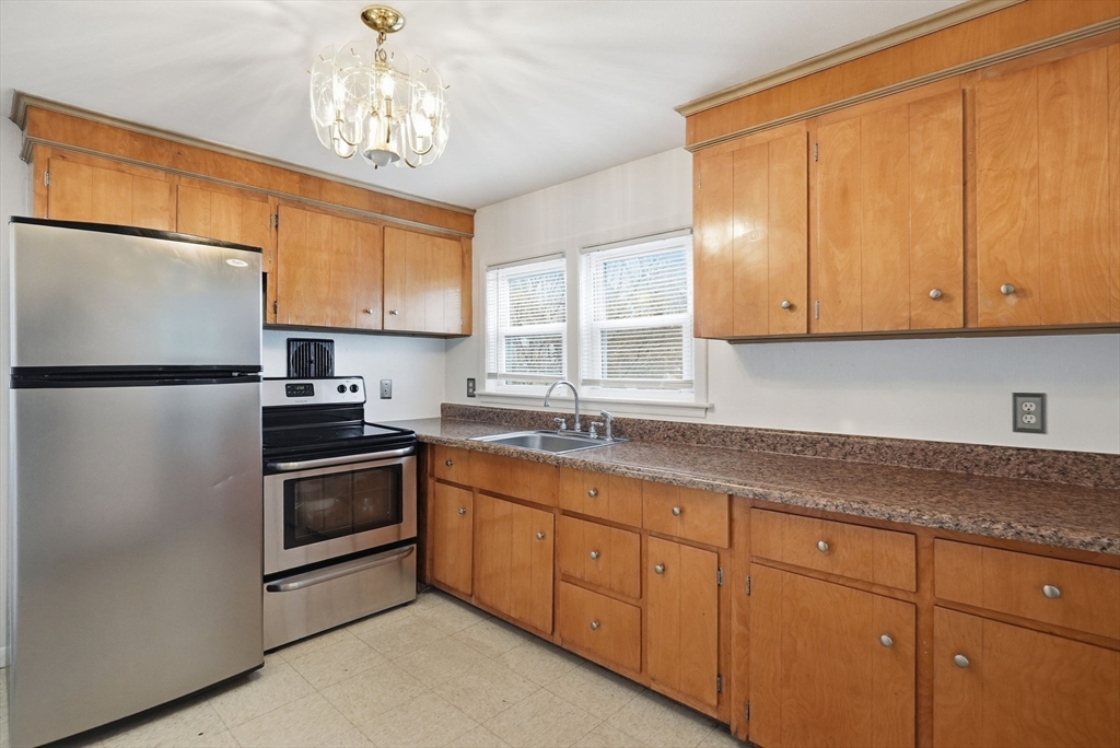 126 Summer Street Boston, MA 02136 - Photo 8 of 28 a kitchen with granite countertop stainless steel appliances a refrigerator sink and cabinets