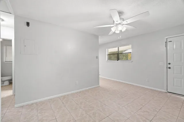 an empty room with fan and windows
