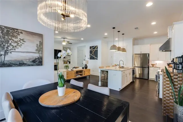 a kitchen with stainless steel appliances kitchen island granite countertop a table and chairs in it